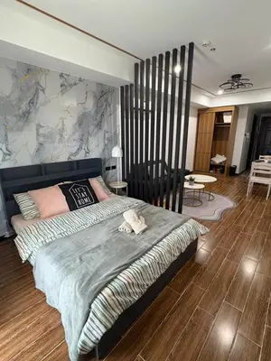 a bedroom with a large bed with a wall at Sybaysuites staycation near Okada COD MOA NAIA in Manila