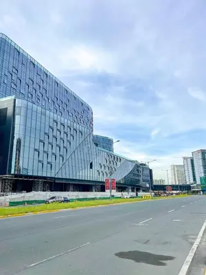 a large glass building with a road in front of it at Modern & Luxury 3BR near Solaire, Okada, Airport in Manila