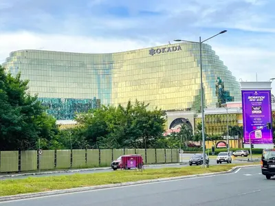 a large building with a sign on the side of a road at Modern & Luxury 3BR near Solaire, Okada, Airport in Manila