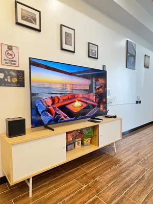 a large flat screen tv on a stand in a living room at Sybaysuites staycation near Okada COD MOA NAIA airport Solaire MSV1808H in Manila