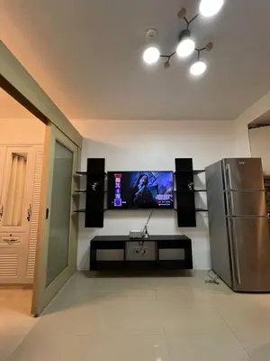 a living room with a flat screen tv and speakers at Sea Residences Fireworks View - Reynil in Manila