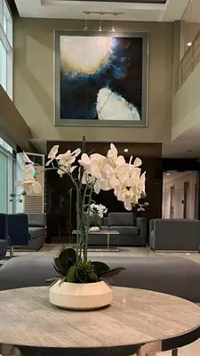 a vase of white flowers on a table in a lobby at Sea Residences Fireworks View - Reynil in Manila