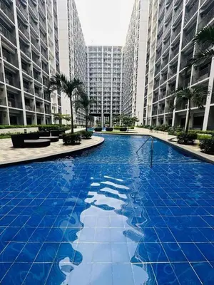 a large blue pool in a city with tall buildings at ElcaPri Staycation - Shore 2 Residences in Manila