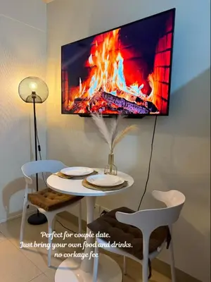 a tv hanging on a wall next to a table at ElcaPri Staycation - Shore 2 Residences in Manila