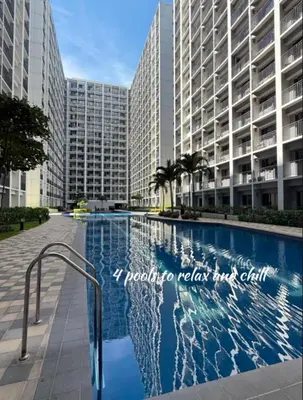 a swimming pool in front of a large building at ElcaPri Staycation - Shore 2 Residences in Manila