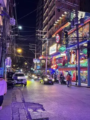 a busy city street at night with cars and signs at Nikki's cozy home makati in Manila