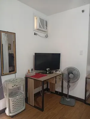 a room with a desk with a television and a fan at Nikki's cozy home makati in Manila