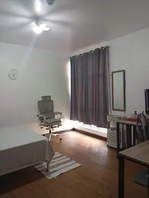 a bedroom with a bed and a chair and a window at Nikki's cozy home makati in Manila