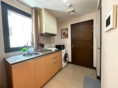a kitchen with a sink and a washing machine at Cozy Studio in Salcedo Village Makati in Manila