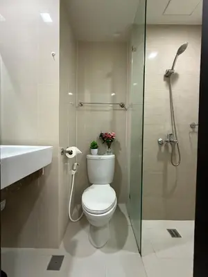 a bathroom with a toilet and a sink and a shower at Cozy Studio in Salcedo Village Makati in Manila