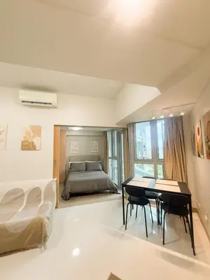 a bedroom with a bed and a table and chairs at City View Stay in Uptown BGC in Manila