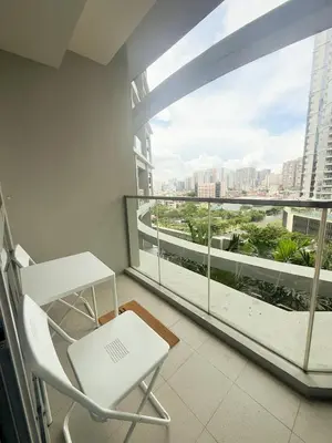 a balcony with a white chair and a large window at City View Stay in Uptown BGC in Manila