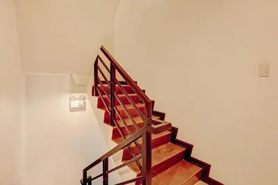 a staircase in a house with wooden railings at Super OYO Capital O 232 Nest Nano Suites Fort in Manila