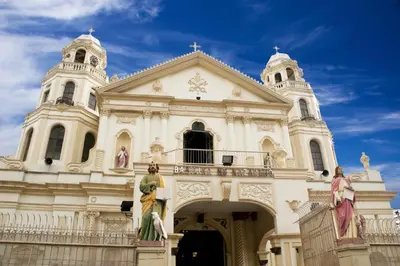 a large white church with two women standing on a balcony at The Quarters in Manila
