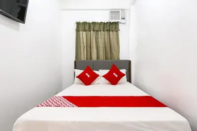 a bedroom with a bed with red pillows at OYO 736 Jade Apartelle in Cabuyao