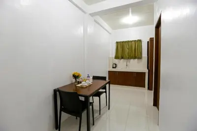 a dining room with a wooden table and chairs at OYO 736 Jade Apartelle in Cabuyao