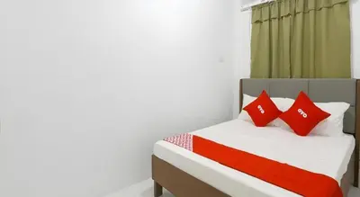 a bedroom with a bed with red pillows at OYO 736 Jade Apartelle in Cabuyao