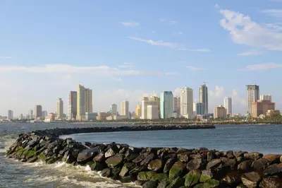 a group of rocks in the water with a city at OYO 766 Ichehan Apartments in Manila