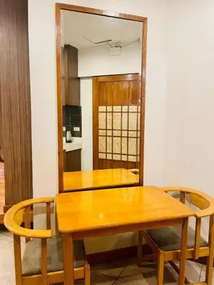 a wooden table with two chairs and a mirror at Capital O 897 Takara Hotel And Events Place in Calamba