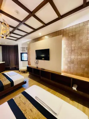 a bedroom with a bed and a flat screen tv at Capital O 897 Takara Hotel And Events Place in Calamba