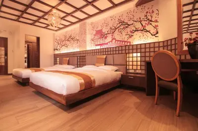 a bedroom with two beds and a chair in it at Capital O 897 Takara Hotel And Events Place in Calamba
