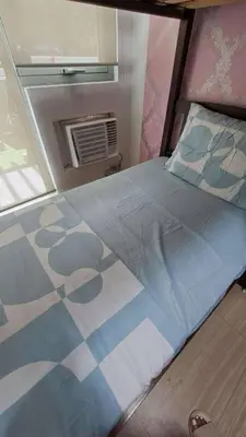 a large bed in a room with a window at AZURE BICUTAN MAUI G14 TOWER POOL View in Manila