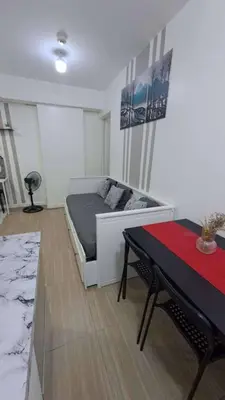 a bedroom with a bed and a table in it at AZURE BICUTAN MAUI G14 TOWER POOL View in Manila