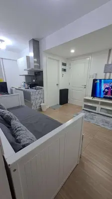 a living room with a large bed and a tv at AZURE BICUTAN MAUI G14 TOWER POOL View in Manila