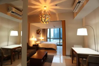 a hotel room with a bed and a living room at 1BR condo at One Uptown Residence in BGC in Manila