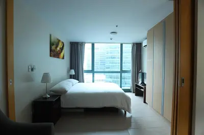 a bedroom with a bed and a large window at 1BR condo at One Uptown Residence in BGC in Manila