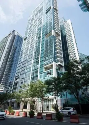 a tall building with cars parked in front of it at 1BR condo at One Uptown Residence in BGC in Manila