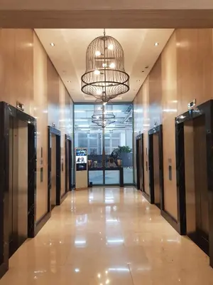 a hallway in a building with a large chandelier at 1BR condo at One Uptown Residence in BGC in Manila