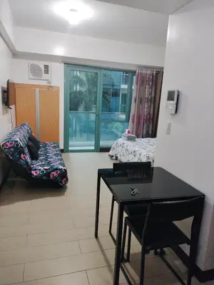 a living room with a table and a chair at Pasay Condotel Near Airports in Manila