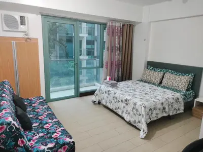 a living room with a bed and a couch at Pasay Condotel Near Airports in Manila