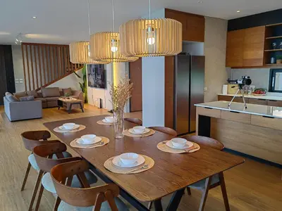 a dining room table with chairs and a kitchen at The LakeFront Villa in Binangonan
