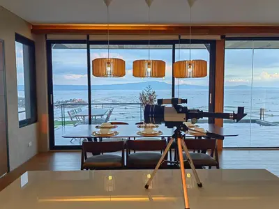 a camera on a tripod in a room with a table at The LakeFront Villa in Binangonan