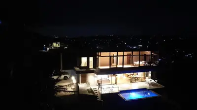 a night view of a house with a swimming pool at The LakeFront Villa in Binangonan