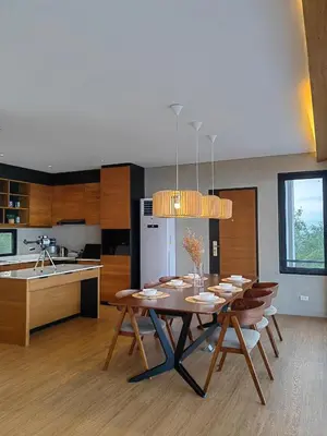 a dining room with a table and a kitchen at The LakeFront Villa in Binangonan