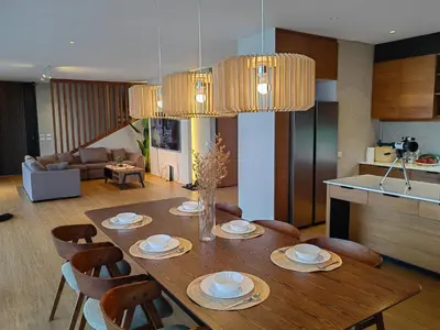 a dining room table with chairs and a kitchen at The LakeFront Villa in Binangonan