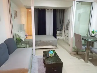 a living room with a bed and a mirror at Azure Urban Resort Residences in Manila