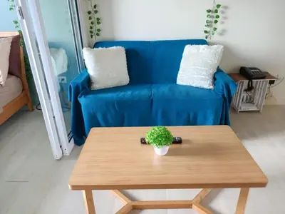a living room with a blue couch and a table at Azure Urban Resort Residences in Manila
