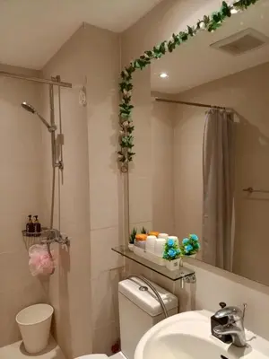 a bathroom with a toilet and a sink and a mirror at Azure Urban Resort Residences in Manila