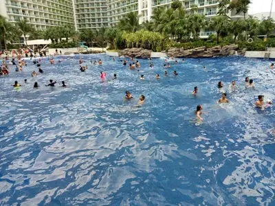 a group of people swimming in a large swimming pool at Azure Urban Resort Residences in Manila