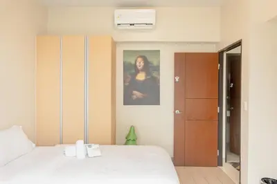 a bedroom with a bed and a picture of a woman at Family 2 Bedroom and 1 living Room Suite with Balcony - One Uptown, BGC in Manila