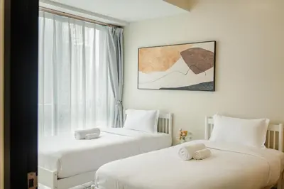 two beds in a room with a window at Family 2 Bedroom and 1 living Room Suite with Balcony - One Uptown, BGC in Manila