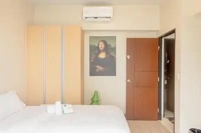 a bedroom with a bed and a picture of a woman at Family 2 Bedroom and 1 living Room Suite with Balcony - One Uptown, BGC in Manila