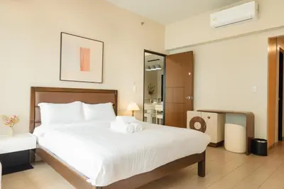 a bedroom with a large bed with towels on it at Family 2 Bedroom and 1 living Room Suite with Balcony - One Uptown, BGC in Manila