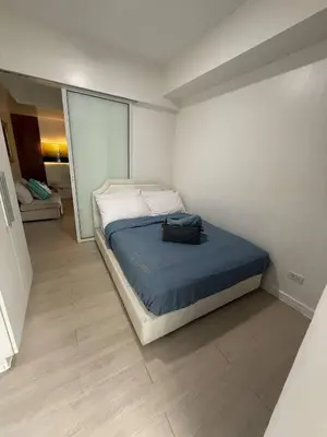 a small bedroom with a bed with a blue blanket at AZURE BICUTAN BORACAY 4FL BEACH POOL View in Manila