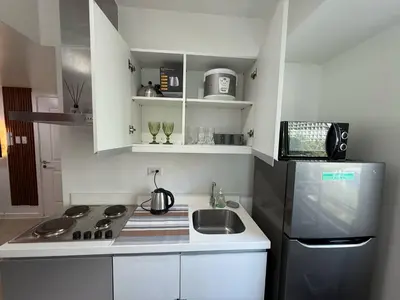 a small kitchen with a sink and a refrigerator at AZURE BICUTAN BORACAY 4FL BEACH POOL View in Manila