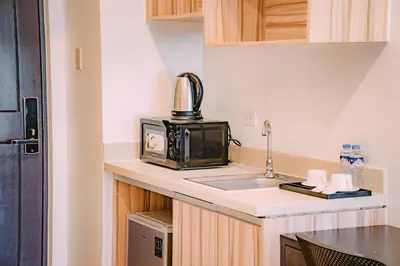 a small kitchen with a sink and a microwave at I Suites Hotel Malate in Malate
